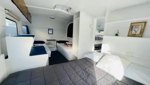 奥克兰Orere Point Top 10 Holiday Park的一间带床和沙发的小卧室