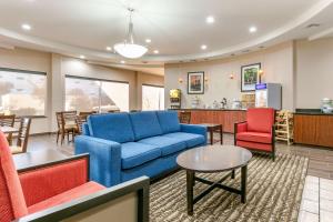 Van BurenComfort Inn and Suites Van Buren - Fort Smith的客厅配有蓝色的沙发和红色的椅子