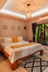 福尔图纳Luxury Villa and Bungalows的一间卧室配有一张大床和一个吊灯。