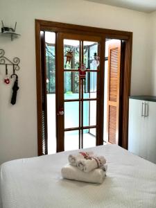 格拉玛多Refúgio na Serra, um espaço para ser desfrutado!的门前床和两条毛巾