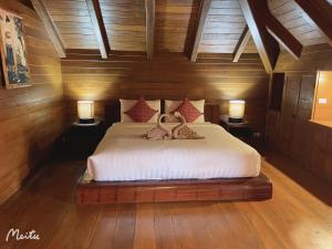 Ban Pa MuangLantana House的一间卧室配有一张带两个天鹅的床