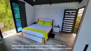 TenaSolaris Glamping Exclusive的一间卧室配有一张带绿色床单的床和一个阳台。