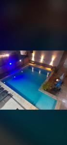 伊瓜苏港法米利亚公寓式酒店的夜间大型蓝色游泳池,灯光照亮
