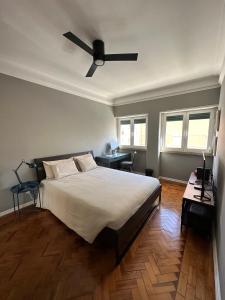 里斯本Rooms to rent in a friendly apartment的一间卧室配有一张床和吊扇