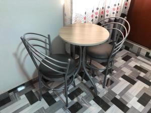 利马Hostal DRABA的一张桌子和椅子,位于一个设有 ⁇ 格地板的房间