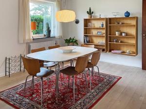 岑讷Holiday home Tønder III的一间位于地毯上的带桌椅的用餐室