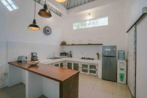 塞米亚克Villa Teman的一间白色的大厨房,配有木制台面