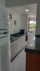 皮拉图巴Encantador Apto NOVO, climatizado e confortável - 200m das Thermas的一间带白色柜台和冰箱的大厨房
