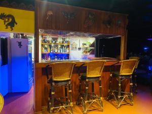 功孟海滩Krabi Villa Phu Khao Private Resort的冰箱前带四把椅子的酒吧