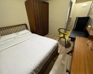 雅加达Choska Residence的一间卧室配有一张床、一张桌子和一把椅子
