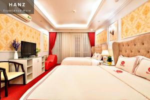河内HANZ Kieu Anh Hotel的一间酒店客房,设有两张床和电视