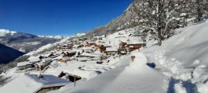 MontagnySki Chalet - Chez Helene Ski fb的山上积雪覆盖的村庄