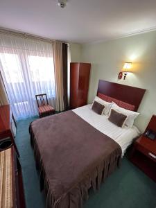 布哈拉Inturist Hotel Classic Grand Bukhara的酒店客房设有一张大床和一台电视。