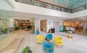 芽庄Florida Nha Trang Hotel的大厅,大楼里摆放着蓝色和黄色的椅子