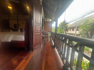 琅勃拉邦XiengThong KhounPhet GuestHouse的阳台卧室(带一张床)