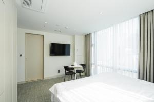 首尔Hotel Vert的一间卧室配有一张床、一张桌子和一台电视。
