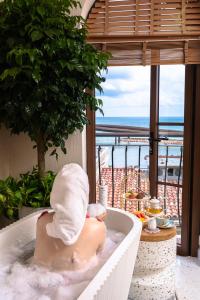 富国Roma Hotel Phu Quoc - Free Hon Thom Island Waterpark Cable Car的男人在浴缸里,毛巾