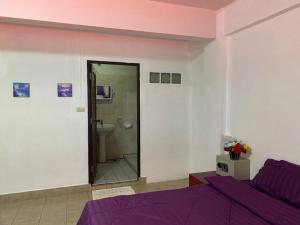 乔木提恩海滩Chai Ben guesthouse的一间带紫色床的卧室和一间浴室