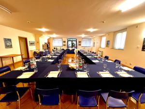 维泰博Nazareth Residence的大型会议室设有长桌和蓝色椅子