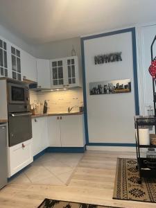 滨海图维列Le Bleu的厨房配有白色橱柜和蓝色的墙壁