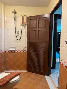 芭东海滩Hideaway House Patong的浴室设有棕色的门和卫生间。