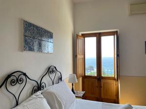PollaraHotel La Locanda Del Postino的一间卧室设有一张床,享有海景