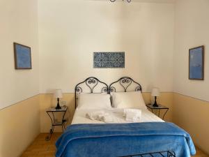 PollaraHotel La Locanda Del Postino的一间卧室配有一张带蓝色毯子的床