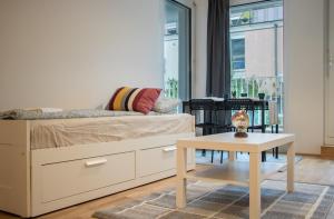 维也纳Flat2go modern apartments - Harmony of city and nature的一间卧室配有一张床、一张桌子和一个窗户。