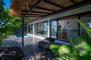 涛岛Lunar Villas Koh Tao - Luxury Private Pool Villas的一个带椅子的户外庭院和房子