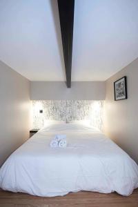 里昂Duplex-Université的卧室配有白色的床和2条毛巾
