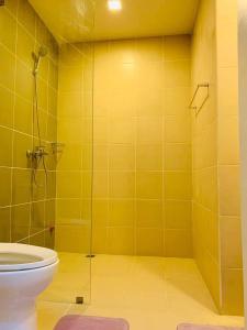 伊洛伊洛Unit 3J Signature Suites, Lafayette Megaworld的黄色的浴室设有卫生间和淋浴。