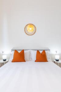拉波拉诺泰尔梅L'Acqua e la Pietra的卧室配有带橙色枕头的白色床