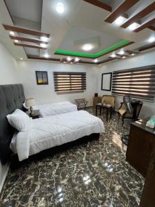 瓦迪穆萨Petra balcony apartment的卧室配有一张白色大床和椅子