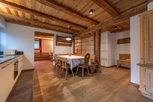 奥蒂塞伊Agriturismo Apartments Tuene的厨房以及带桌椅的用餐室。