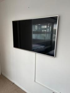BroadwaterNISHAT & AMAAN的白色墙壁上的平面电视