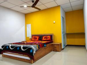 萨三吉尔Madhav Farmhouse的一间卧室配有一张黄色墙壁的床