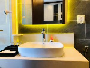 海阳Apec Mandala hotel & suites Hải dương的浴室设有白色水槽和镜子