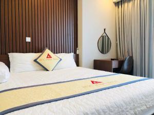 海阳Apec Mandala hotel & suites Hải dương的酒店客房的床上有两个红色鸟