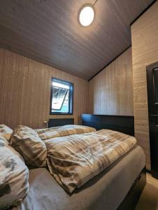 朗伊尔城Flott enderekkehus med fantastisk utsikt的一间带两张床铺的卧室,位于带木墙的房间内