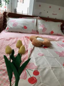 芽庄Lucky Home的泰迪熊躺在床上,床上种满了鲜花