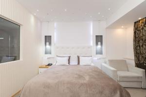 韦莱斯加德尼亚酒店及Spa的卧室配有床、椅子和窗户。