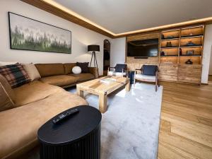 萨梅丹Chic Alpine Elegance: Designer Retreat in Samedan的客厅配有沙发和桌子