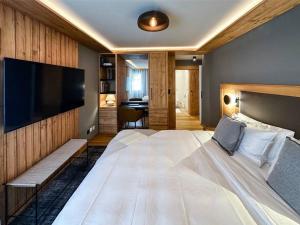 萨梅丹Chic Alpine Elegance: Designer Retreat in Samedan的一间卧室配有一张大床和一台平面电视