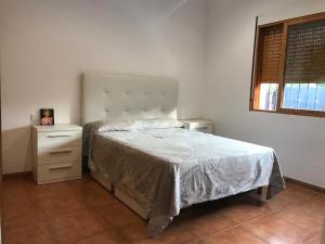 卡斯特利翁-德拉普拉纳Villa Holiday的一间卧室配有一张床、一个梳妆台和一扇窗户。