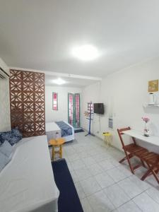嘎林海斯港Chalés Caiçara Serrambi的客房设有两张床、一张桌子和一张沙发。