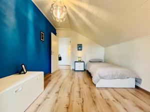 纳沙泰尔A La Côte的一间卧室设有一张床和蓝色的墙壁