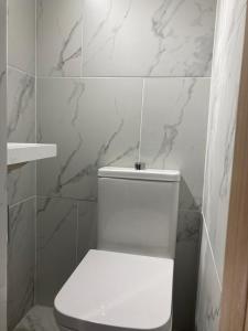 SurbitonTwin home with free parkings, Surbiton, Kingston upon Thames, Surrey, Greater London, UK!的浴室铺有大理石瓷砖,设有白色卫生间。