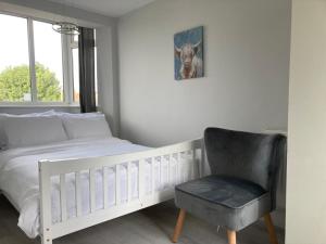 SurbitonTwin home with free parkings, Surbiton, Kingston upon Thames, Surrey, Greater London, UK!的卧室配有白色的床和椅子