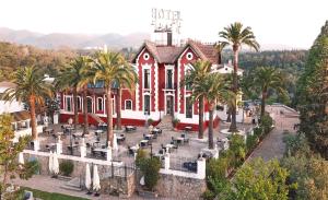 科尔多瓦Hotel Finca Los Abetos的一座大型红色建筑,前面有棕榈树