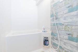横滨Apartment hotel Hana in Yokohama的浴室设有白色卫生间和软管